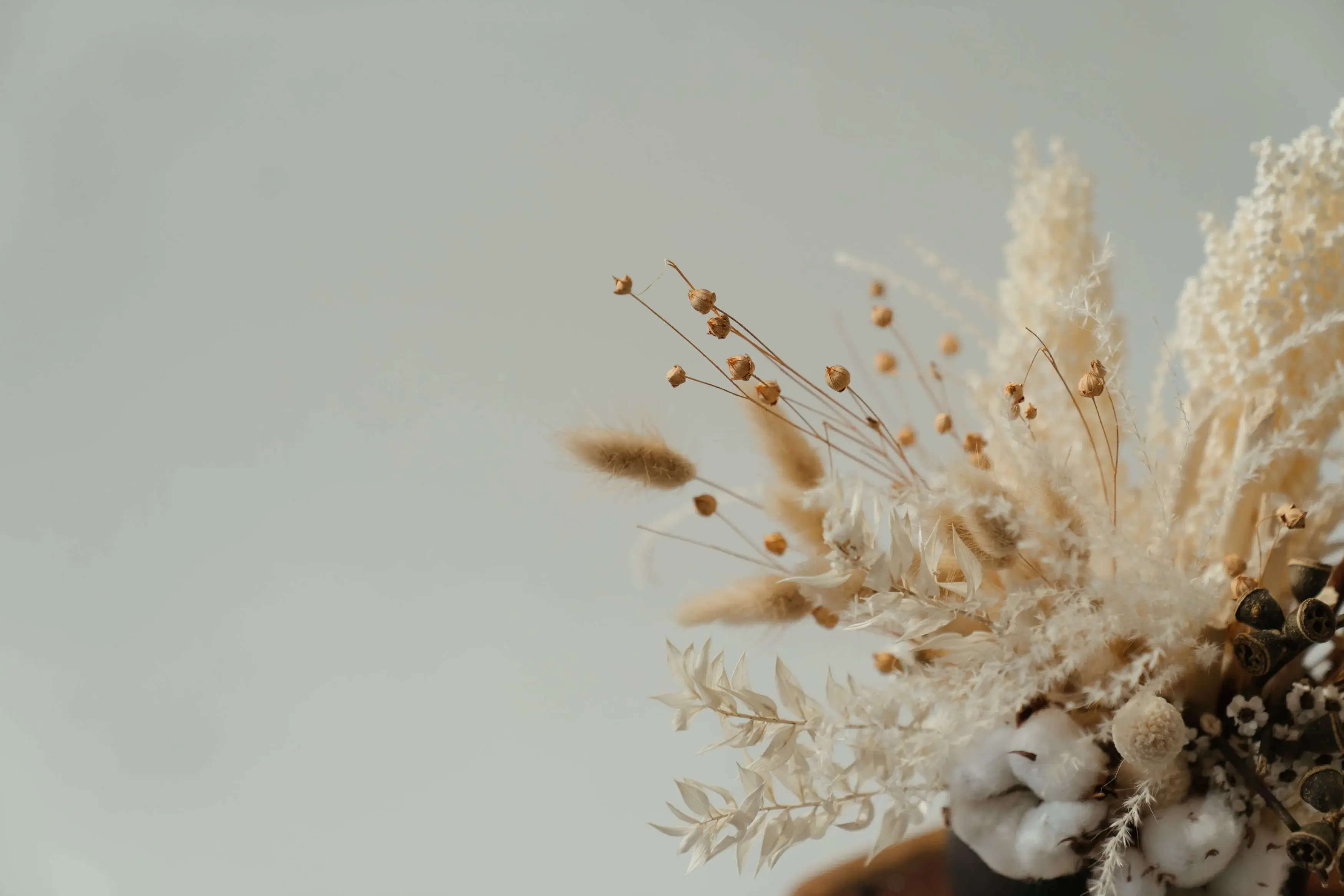 Light colored floral arrangement on a table with a soothing light