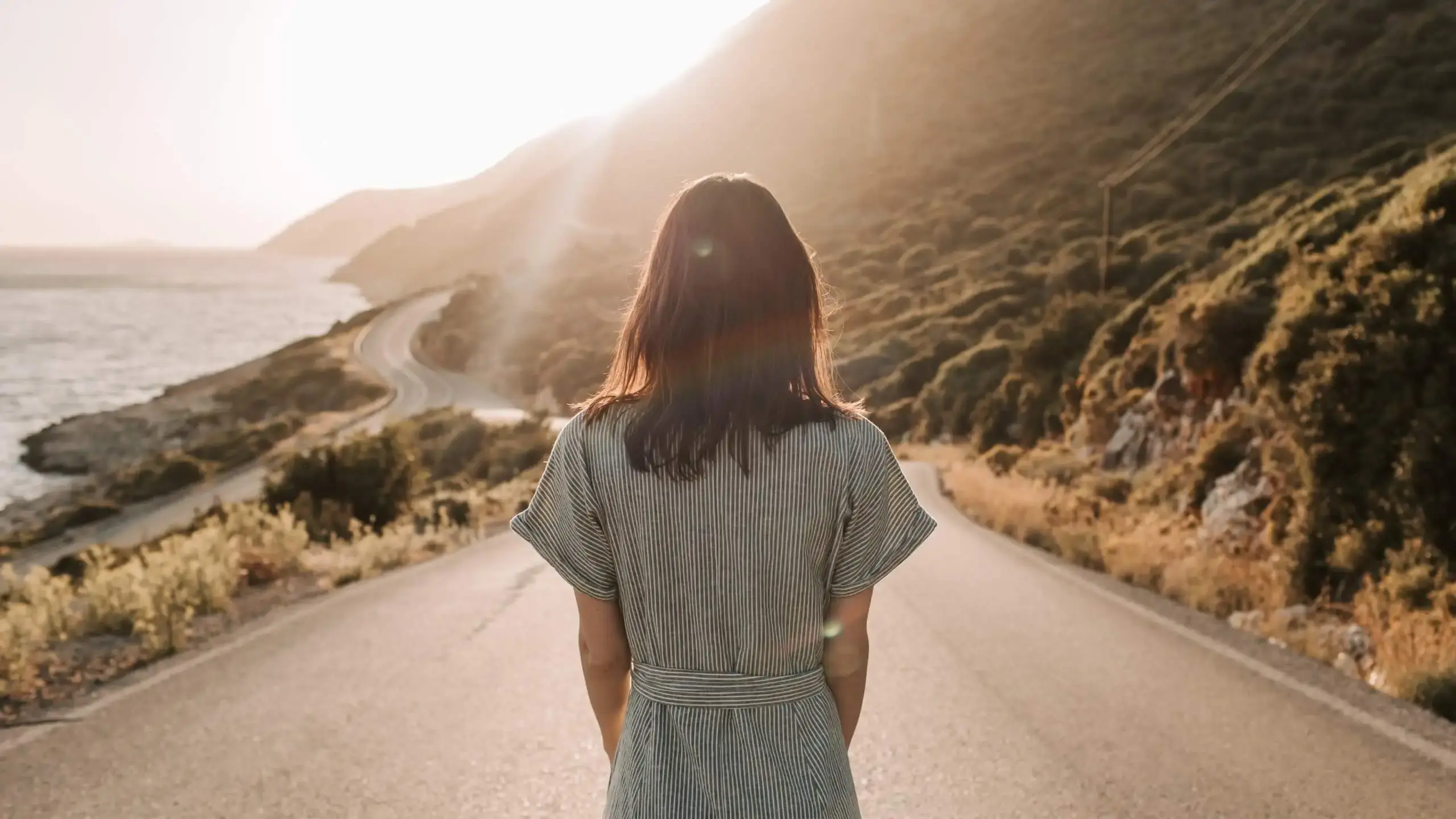 Lonely and depressed woman in her twenties looking off into the sunset contemplating what is next in her life