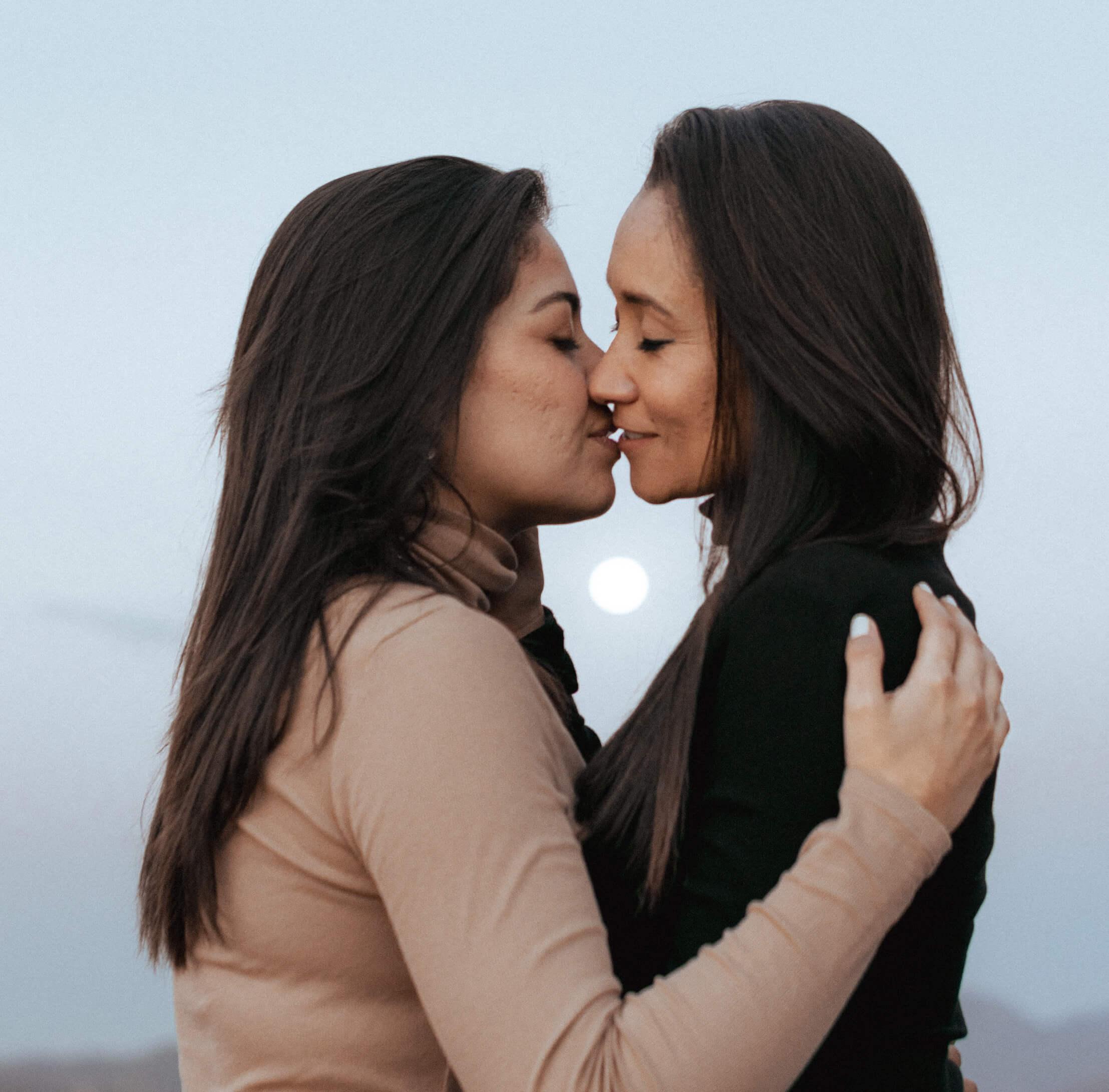 An LGBTQIA+ couple kissing and embracing each other